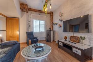 a living room with a couch a table and a tv at Hogar de ZOE in Trujillanos