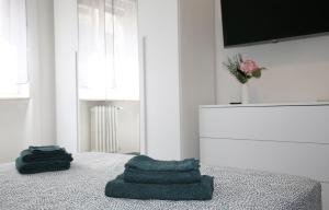 two towels sitting on a bed in a room at Casa MadArt City Centre MXP TrainStation in Gallarate +30 photos