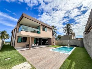 a villa with a swimming pool and a house at Casa com 4 suítes, piscina, a 20m do mar| Milagres in Barra do Camaragibe