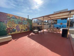 a mural on the side of a building with tables and chairs at Urban Jungle Hostel in San Miguel de Tucumán