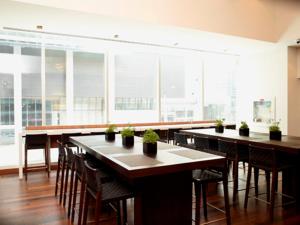 uma grande sala com mesas, cadeiras e janelas em Le Germain Hotel Maple Leaf Square em Toronto