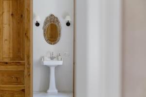 a bathroom with a sink and a mirror on the wall at Aštriosios Kirsnos dvaras in Aštrioji Kirsna