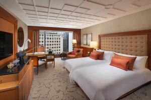 um quarto de hotel com uma cama grande e uma escrivaninha em Mandarin Oriental, Hong Kong em Hong Kong