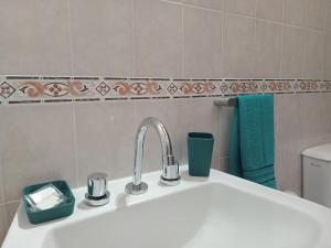 a white sink in a bathroom with a green towel at Refugios del Alma in Villa Las Rosas +13 photos