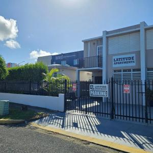 a gate with a sign in front of a building at Latitude Adjustment in San Juan