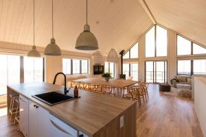 una cucina e un soggiorno con tavoli e sedie di Luna - 5 chambres - 14 personnes a Saint-Férréol-les-Neiges