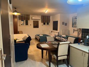 een woonkamer met een keuken en een kamer met een tafel bij 50m from beach in PalaiónTsiflíkion +10 foto's