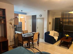 een woonkamer met een tafel en een woonkamer met een bank bij 50m from beach in PalaiónTsiflíkion