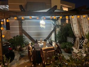 een terras met een tafel, stoelen en planten bij 50m from beach in PalaiónTsiflíkion