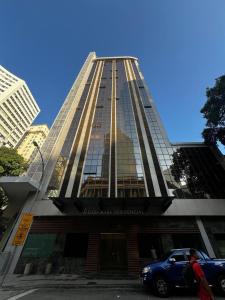 un edificio alto con una macchina parcheggiata di fronte di Casa Mauá 402 a Rio de Janeiro