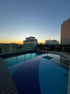 una piscina in cima a un edificio con tramonto di Casa Mauá 402 a Rio de Janeiro