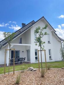 a white house with trees in front of it at Chez manu in Voellerdingen