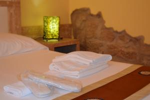 a pile of towels sitting on top of a bed at Butterfly Accommodation in Alghero