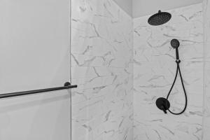 Un baño con ducha con pared de piedra. en Beautiful Green Door Brownstone, en Jersey City