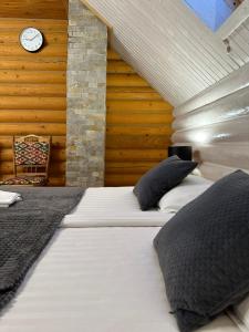 a bedroom with two beds and a clock on the wall at MIRA House in Vorokhta