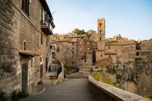 an alleyway in an old town with a tower at Green Home in Ronciglione