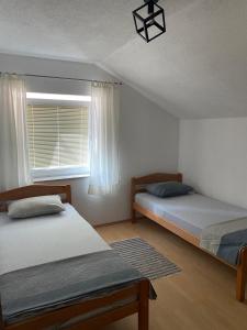 ein Schlafzimmer mit zwei Betten und einem Fenster in der Unterkunft Konak u Gradini in Tomislavgrad