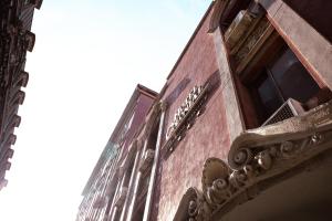 a red brick building with a window and a balcony at Hotel Colonial in Monterrey +6 photos