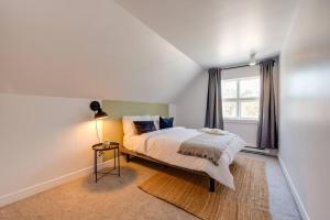 una camera da letto bianca con un letto e una finestra di La Jumelle d'en bas - 5 chambres - 15 personnes a Saint-Férréol-les-Neiges Altre 13 foto