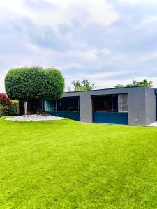 a building with a tree in the middle of a yard at Villa du lac in Arsac