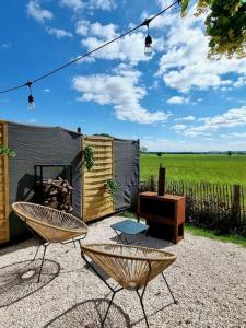 Lisle-sur-TarnにあるTiny House Petite Balnéo Cheminée exterieureのパティオ(椅子2脚、テーブル、フェンス付)