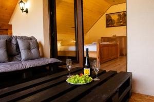 a living room with a table with a bottle of wine and grapes at Agroturystyka domek na Roztoczu Pod lasem u Surajów in Huta Lubycka