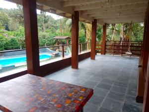 a patio with a table and a swimming pool at Chácara Sonho Meu Juquitiba SP in Juquitiba +38 photos