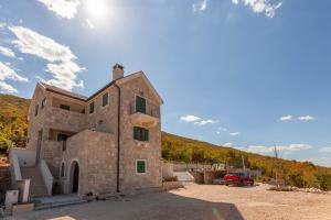 a stone building with a car parked in front of it at Biokovski zagrljaj in Zagvozd