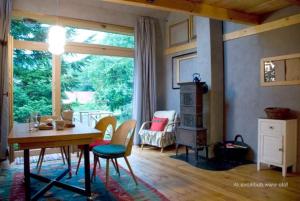 ein Wohnzimmer mit Tisch und Stühlen und einem Fenster in der Unterkunft Cozy Cottage in Staré Hory