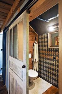 ein Bad mit einem WC und einer Tür in der Unterkunft Cozy Cottage in Staré Hory