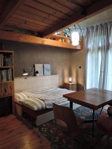 ein Schlafzimmer mit Bett und Tisch und ein Esszimmer in der Unterkunft Cozy Cottage in Staré Hory