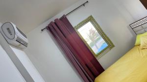 ein Schlafzimmer mit einem roten Vorhang und einem Fenster in der Unterkunft Chalet in Serena resort , El Alamein in Abū Shunaynah + 14 Fotos