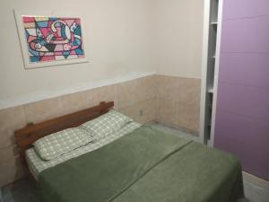 a bed in a room with a painting on the wall at Residencial Barbosa - Apto 102 in Macaé