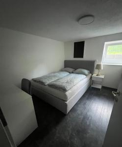 a white bedroom with a bed and a window at Gemütlich Wohnen Sinsheim 2 in Sinsheim
