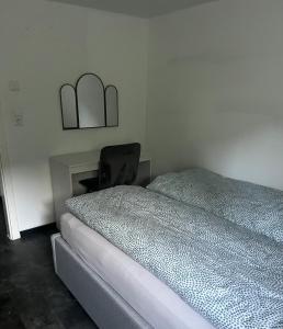 a bedroom with a bed and a chair next to a desk at Gemütlich Wohnen Sinsheim 2 in Sinsheim +4 photos