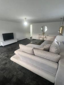 a living room with a white couch and a television at Gemütlich Wohnen Sinsheim 2 in Sinsheim
