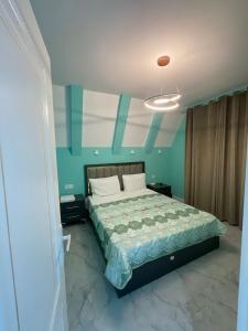 a bedroom with a large bed with blue walls at Quba Aframe Mesə & Gol in İkinci Nügǝdi
