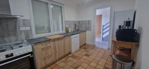 a kitchen with wooden cabinets and a sink and a stove at La désirée in Blangy-sur-Bresle