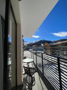 a balcony with two chairs and a table at Didveli, apartment Kesane in Bakuriani