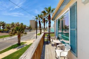 a balcony with a table and chairs and palm trees at Marlin Street Tomehome A in South Padre Island
