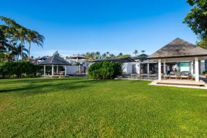 Twin Villas Natai - 7 Bedroom Luxury Beach Front Villa في شاطئ ناتاي: صورة عشب امام المنزل