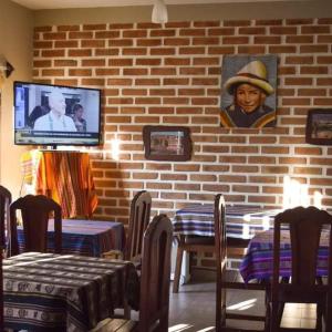un restaurante con mesas y TV en una pared de ladrillo en Hostal amancay, en Cafayate 127 fotos más