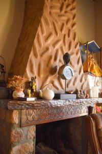 una chimenea de piedra con una pared de madera en Hostal amancay, en Cafayate