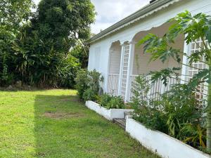 a house with a garden in front of it at La villa créole de Vaughenlieu in Lamentin +1 photo