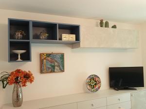 a living room with a tv on a wall at I CACTUS di MiMa in Milano Marittima +36 photos