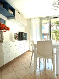 a dining room with a white table and chairs at I CACTUS di MiMa in Milano Marittima