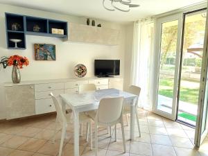 a dining room with a white table and chairs at I CACTUS di MiMa in Milano Marittima