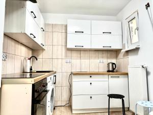 a kitchen with white cabinets and a sink at Familly House in Międzyzdroje