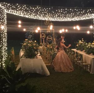 Twin Villas Natai - 7 Bedroom Luxury Beach Front Villa في شاطئ ناتاي: امرأة ترتدي ثوب تقف أمام طاولة +64 صورة