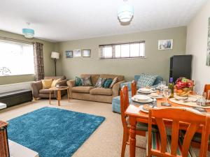 a living room with a table and a couch at Sunny Haven in Weymouth